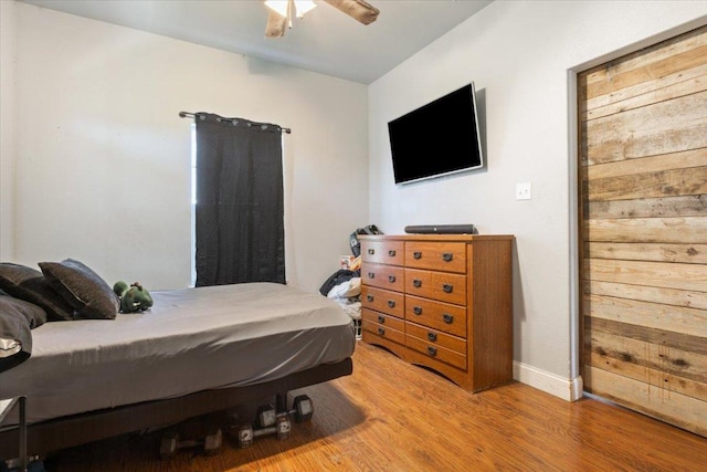 bedroom featuring baseboards, a ceiling fan, and wood finished floors