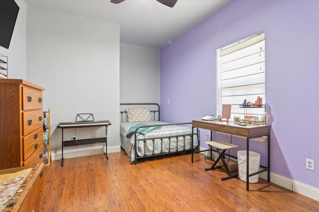 bedroom with wood finished floors and baseboards