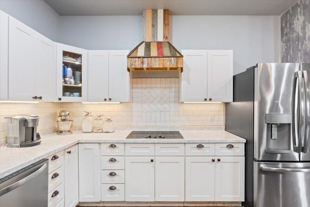 kitchen featuring stainless steel appliances, backsplash, wall chimney exhaust hood, and white cabinetry