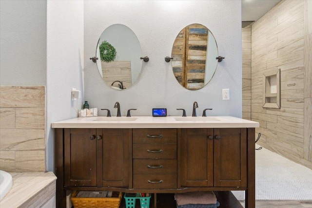 bathroom with a sink, a tub to relax in, and double vanity