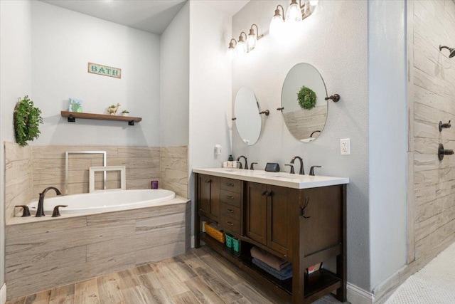 bathroom with a sink, wood finished floors, double vanity, and a bath