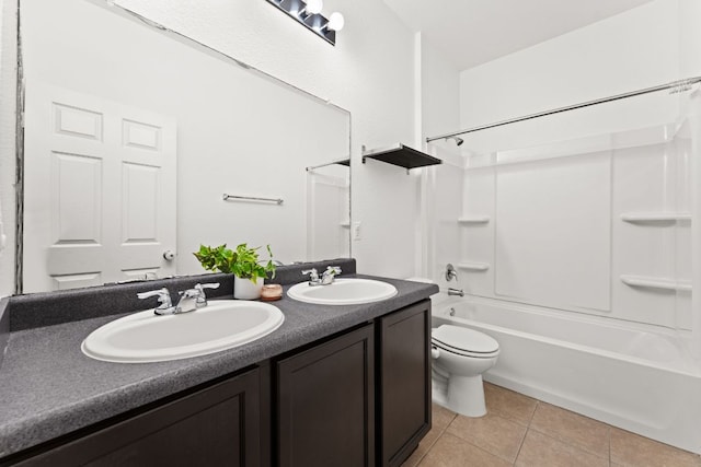 bathroom featuring a sink, toilet, double vanity, and tile patterned flooring