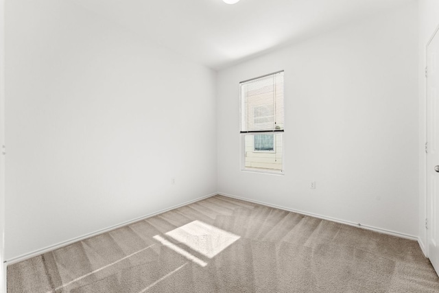 spare room featuring light colored carpet