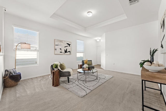 living area with carpet, baseboards, visible vents, a tray ceiling, and ornamental molding