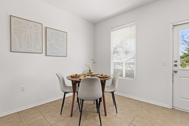 dining space with light tile patterned floors and baseboards