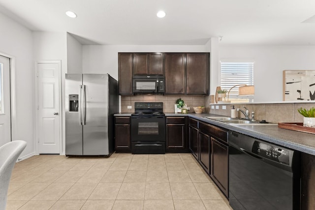 kitchen featuring black appliances, a sink, tasteful backsplash, light tile patterned floors, and dark brown cabinets