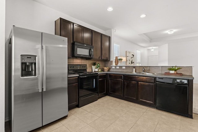 kitchen with backsplash, dark brown cabinetry, a peninsula, black appliances, and a sink