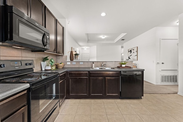 kitchen with visible vents, backsplash, black appliances, a raised ceiling, and a sink