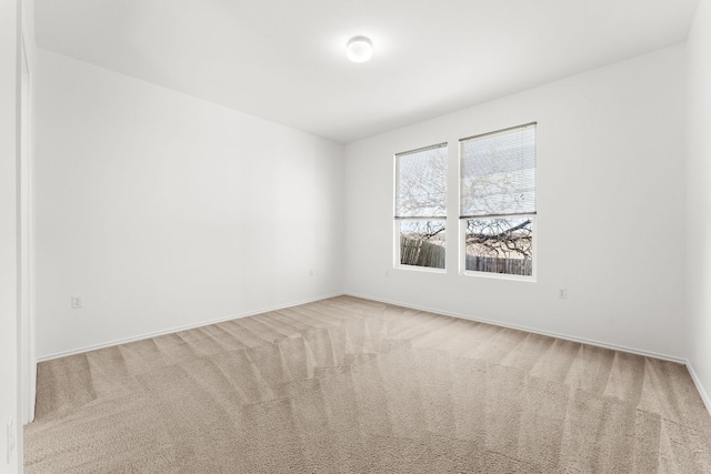 spare room featuring baseboards and carpet floors