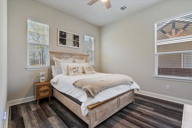 bedroom featuring visible vents, multiple windows, baseboards, and dark wood-style flooring