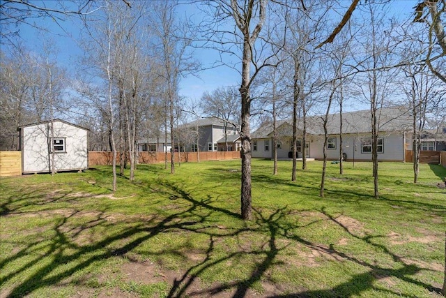 view of yard with a storage unit, an outdoor structure, and fence