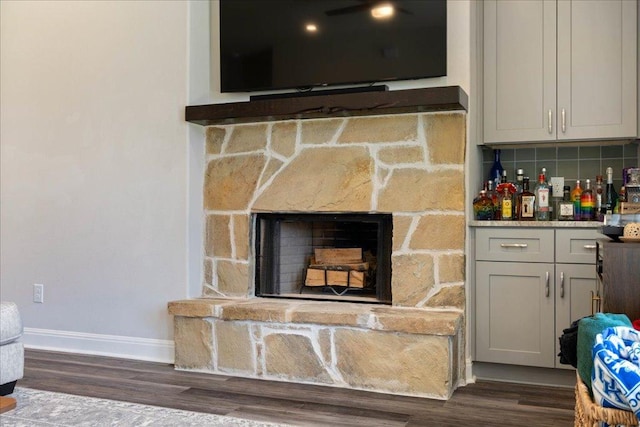 details with decorative backsplash, a fireplace, baseboards, and wood finished floors