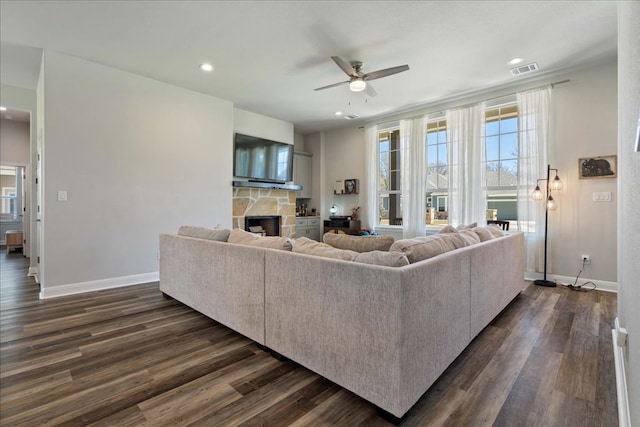 living area featuring visible vents, baseboards, and dark wood-type flooring