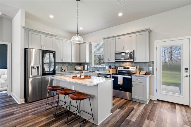 kitchen featuring a sink, stainless steel appliances, dark wood-style flooring, and decorative backsplash