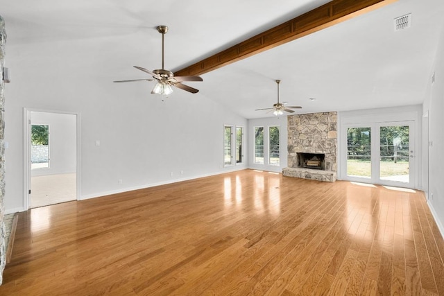 unfurnished living room with plenty of natural light, a fireplace, visible vents, and light wood-type flooring