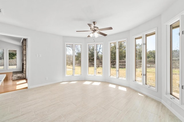 unfurnished sunroom with plenty of natural light, visible vents, and ceiling fan