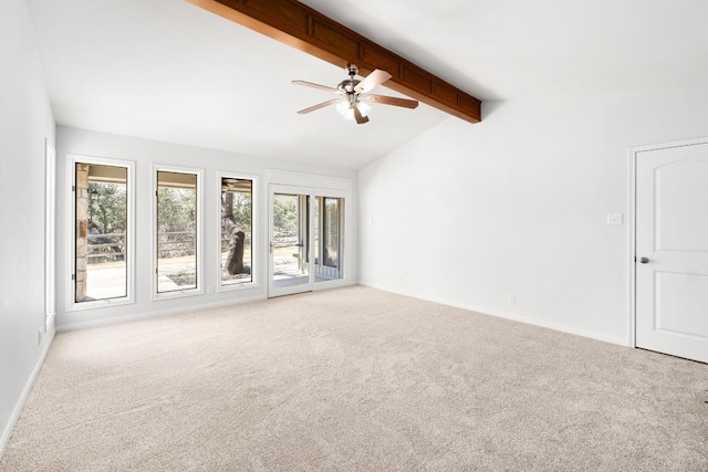 carpeted empty room featuring lofted ceiling with beams, baseboards, plenty of natural light, and ceiling fan