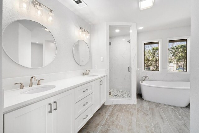 107 Boot Hl, Horseshoe Bay, TX 78657 - bathroom featuring double vanity, a marble finish shower, a freestanding bath, and recessed lighting