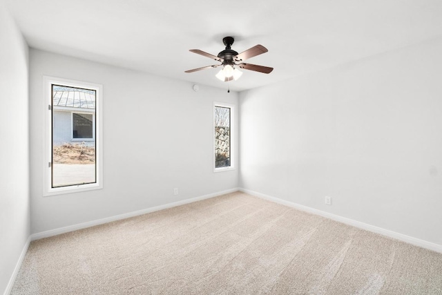 unfurnished room featuring plenty of natural light, light colored carpet, and baseboards