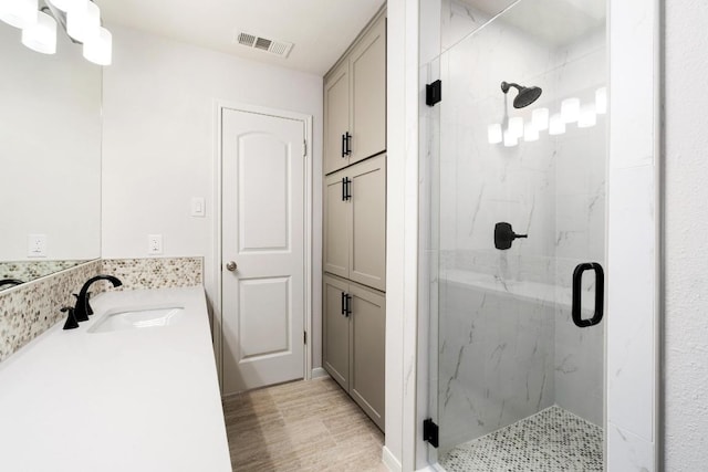 bathroom featuring a marble finish shower, visible vents, and vanity