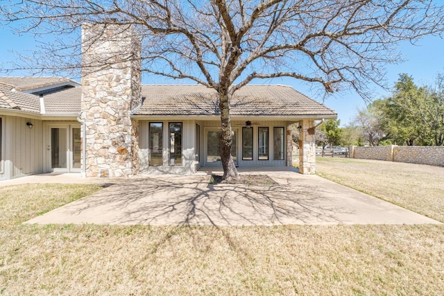 107 Boot Hl, Horseshoe Bay, TX 78657 - back of property with a tiled roof, board and batten siding, a chimney, a patio area, and french doors