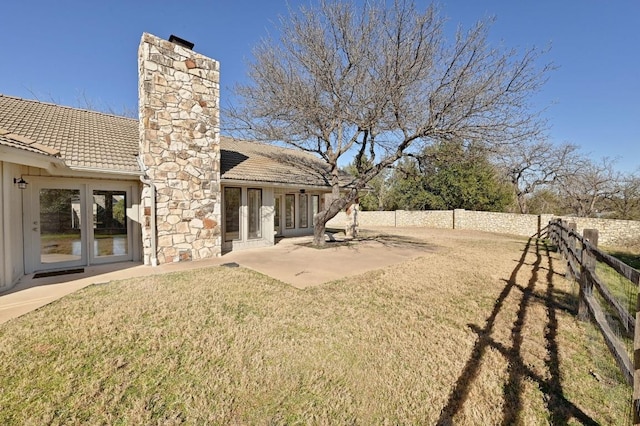 view of yard featuring a patio, a fenced backyard, and french doors