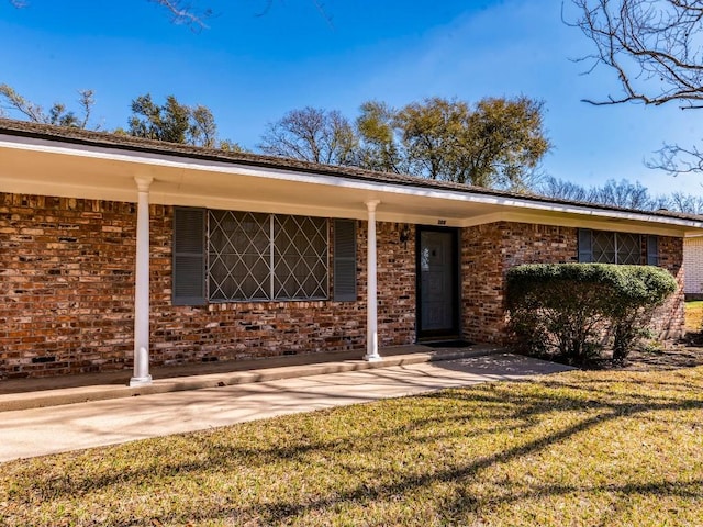 view of front of property featuring brick siding and a front lawn