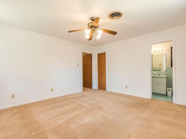 unfurnished bedroom with a sink, baseboards, visible vents, and light carpet