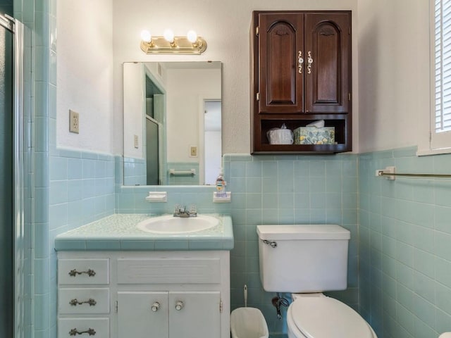 bathroom with an enclosed shower, toilet, tile walls, and vanity