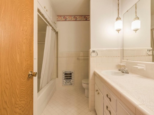 full bathroom featuring a wainscoted wall, toilet, heating unit, tile walls, and vanity