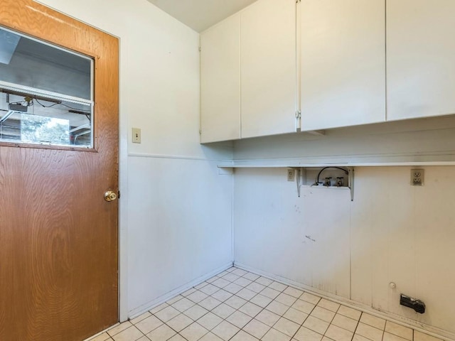 washroom with hookup for a washing machine, light tile patterned floors, and cabinet space