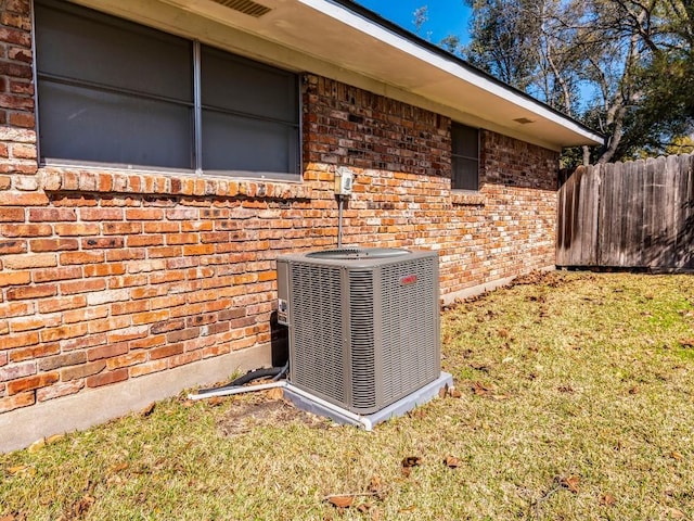 details with brick siding, central AC, and fence