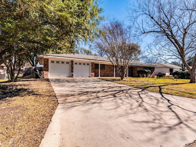 single story home with driveway, brick siding, an attached garage, and fence