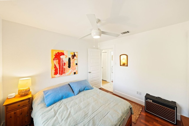 bedroom with a ceiling fan, wood finished floors, baseboards, and visible vents