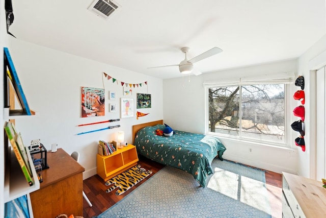 bedroom with baseboards, wood finished floors, visible vents, and ceiling fan