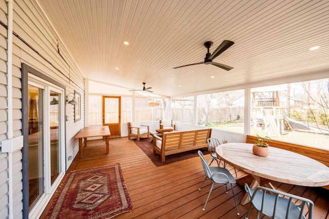 deck with outdoor lounge area, a ceiling fan, and fence