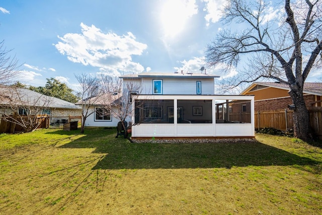 back of property featuring a lawn, a fenced backyard, and a sunroom