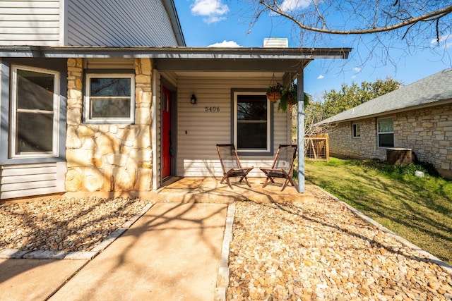 doorway to property with stone siding and a chimney