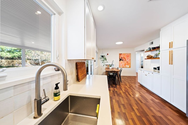 kitchen featuring a sink, light countertops, dark wood-style flooring, and white cabinetry