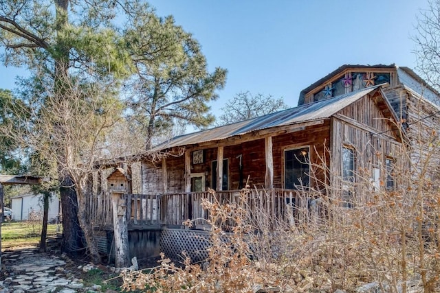 view of side of property with metal roof and an outdoor structure