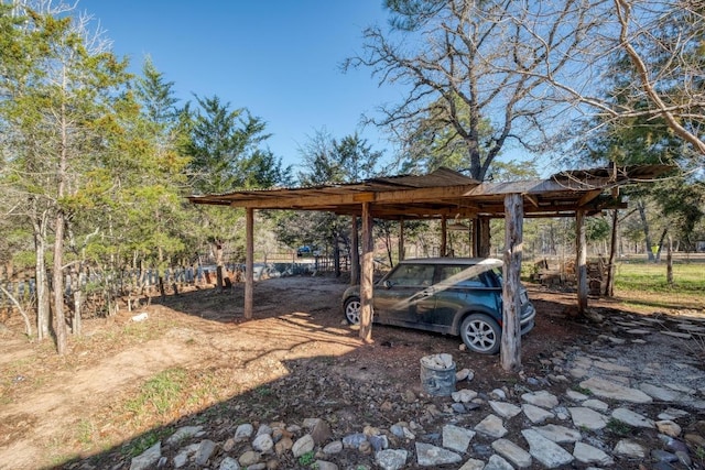 view of yard with a detached carport and dirt driveway