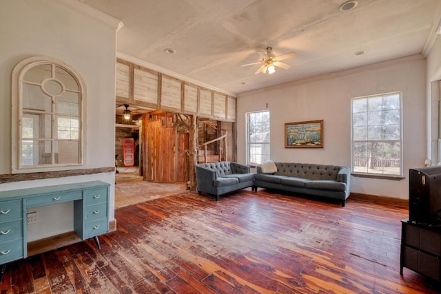 living area with a ceiling fan, crown molding, dark wood-style floors, and baseboards