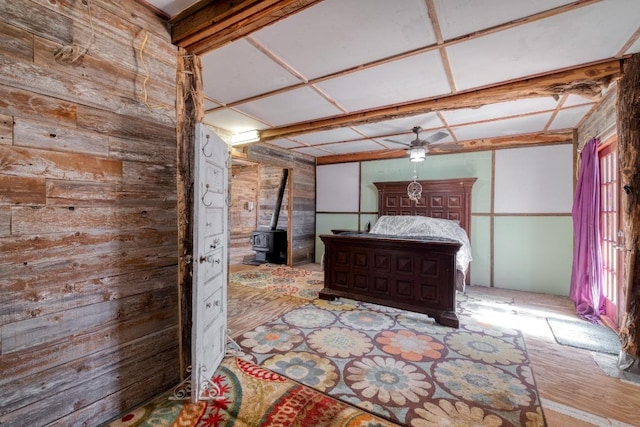 unfurnished bedroom with wood walls and a wood stove