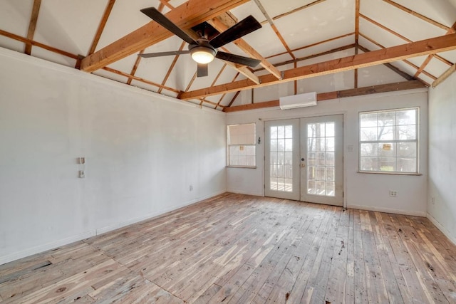 unfurnished room with a wall mounted air conditioner, french doors, high vaulted ceiling, a ceiling fan, and wood-type flooring