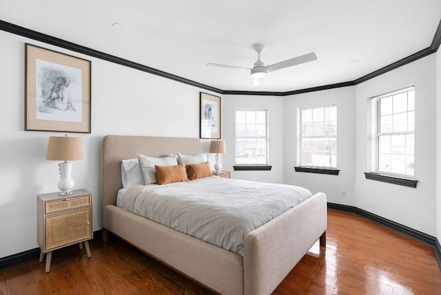 bedroom featuring ceiling fan, baseboards, wood finished floors, and ornamental molding