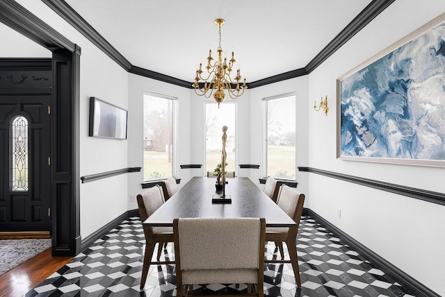 dining area featuring baseboards, a chandelier, and crown molding