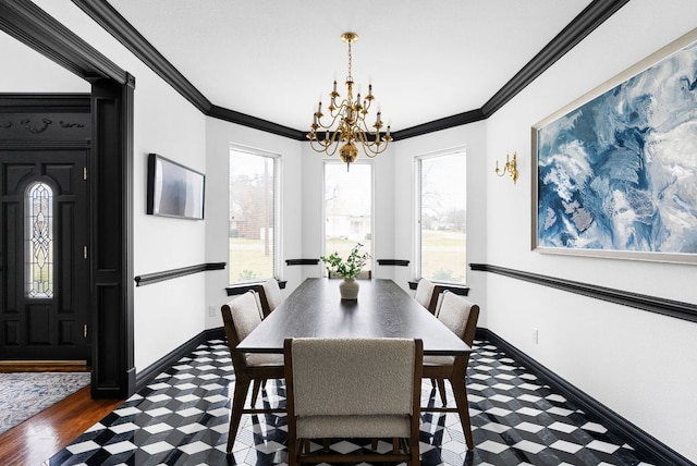 dining space with a notable chandelier, baseboards, and ornamental molding