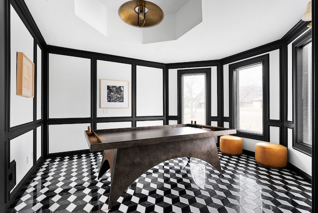 dining area featuring a raised ceiling and a decorative wall