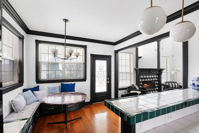 interior space featuring breakfast area, wood finished floors, a wealth of natural light, and crown molding