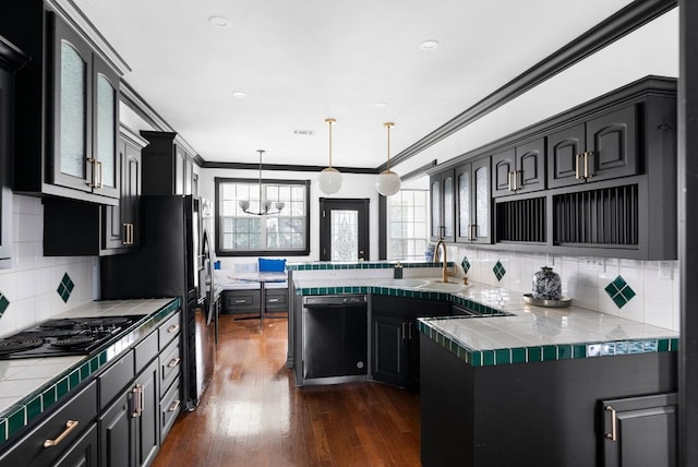 kitchen with black appliances, a sink, dark wood-style floors, a peninsula, and crown molding